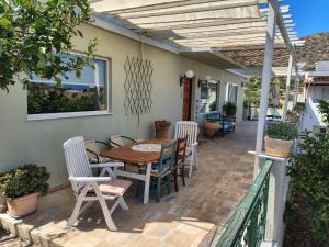 a patio with a wooden table and chairs on a house at Christina's Cottage in Agios Nikolaos