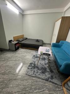a room with a bed and a couch and a table at Mayhome in Long Biên