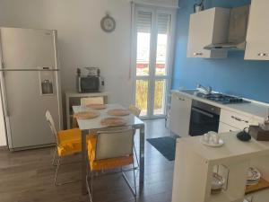a kitchen with a table and chairs and a refrigerator at Casa Biancola, Novara Centro in Novara