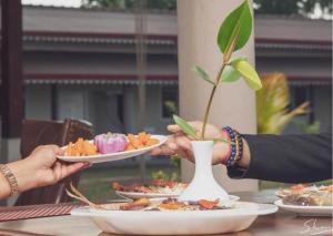 two people holding plates of food on a table at Nilakma Lagoon in Negombo