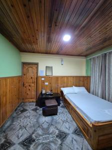 a bedroom with a large bed and a wooden ceiling at Tilanjali Stay in Soreng