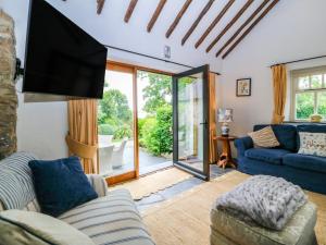 a living room with a tv and a couch at Tyddyn Iolyn in Benllech