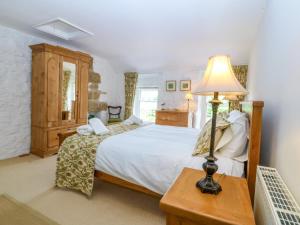 a bedroom with a bed and a lamp on a table at Tyddyn Iolyn in Benllech