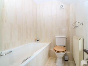 a bathroom with a toilet and a bath tub at Tyddyn Iolyn in Benllech +47 photos