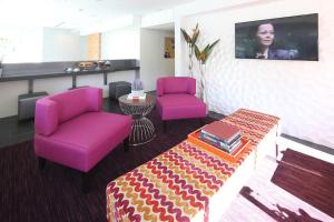 a waiting room with two purple chairs and a table at Lexen Hotel - Hollywood in Los Angeles