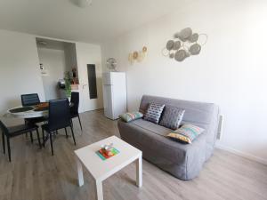 a living room with a couch and a table at APPARTEMENT à 5 mn de la plage in Saint-Hilaire-de-Riez