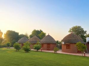 a row of huts with thatched roofs in a yard at Urban Dhani in Gurgaon