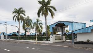 洛坎普頓的住宿－大衛汽車旅館，一条种有棕榈树的街道和一座蓝色的建筑