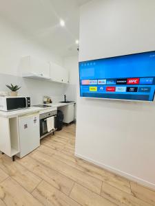 a kitchen with a large tv on a wall at Studio Parking privé in Guéret