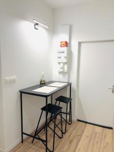 a black table with two stools in a room at Studio Parking privé in Guéret