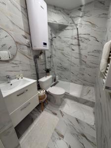 a white bathroom with a toilet and a sink at Studio Parking privé in Guéret