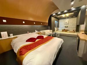 a bedroom with a large bed with red pillows on it at Hotel Shuyukan (Adult Only) in Izumi-Sano