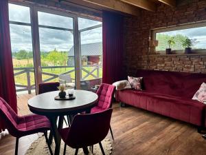 a living room with a red couch and a table at Hulaj Dusza - dom nad stawem in Cisów
