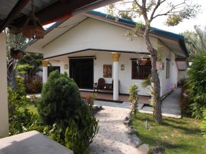 a small white house with a porch at Ryans Resort in Prasat