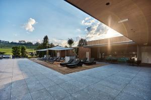 a building with a patio with chairs and tables at Landhotel Wratschko - Wirtshaus - Gamlitz - ehem Hotel am Marktplatz in Gamlitz
