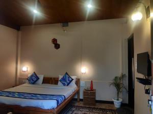 a bedroom with a bed and a tv on the wall at लेक एंड वुड्स in Bhīm Tāl +18 photos