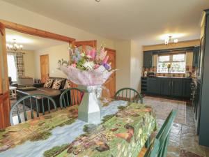 a dining room table with a vase of flowers on it at The Sperrin Getaway in Omagh