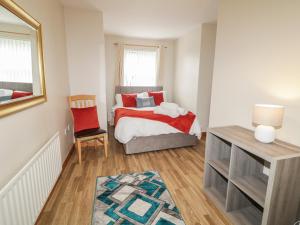 a small bedroom with a bed and a chair at The Sperrin Getaway in Omagh