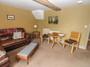 a living room with a couch and a table and chairs at Ewe Cottage in Ripon