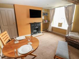 a living room with a table and a fireplace at Ewe Cottage in Ripon