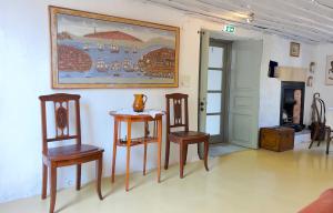 a room with two tables and chairs and a painting on the wall at Rallou House Hydra in Hydra +43 photos