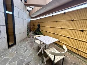 a table and chairs sitting next to a wall at Hotel Shuyukan (Adult Only) in Izumi-Sano