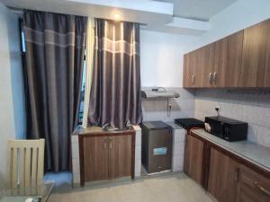a small kitchen with wooden cabinets and a window at Mtg Apartment in Rubavu