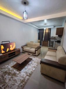 a living room with two couches and a flat screen tv at Mtg Apartment in Rubavu