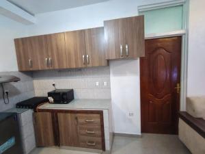 a kitchen with wooden cabinets and a counter top at Mtg Apartment in Rubavu +6 photos
