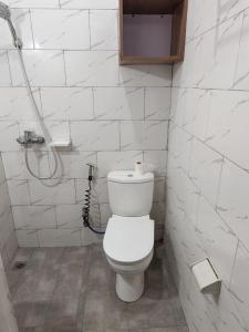 a white bathroom with a toilet and a shower at Mtg Apartment in Rubavu