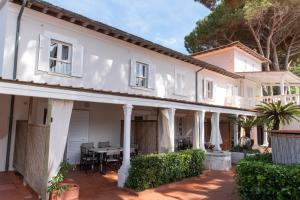 a white house with a patio and a table at Residence Hotel Villa Mare in Portoferraio