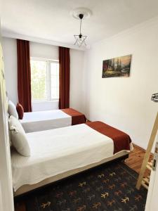a hotel room with two beds and a window at KAŞ MERKEZ İMREN APART 2 in Kaş