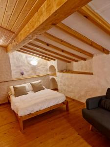 a bedroom with a bed in a room with wooden ceilings at Casa Aldea l'Ayalga in Beloncio