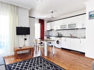 a kitchen and dining room with white cabinets and a table at KAŞ MERKEZ İMREN APART 2 in Kaş