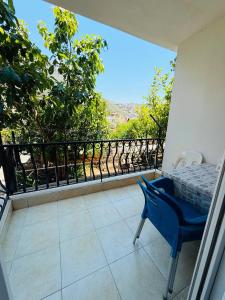 a balcony with a blue chair and a view at KAŞ MERKEZ İMREN APART 2 in Kaş