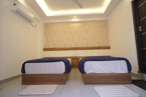 a room with two beds with blue cushions at KPN Tower in Erāttupetta +8 photos