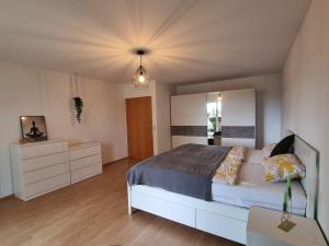 a bedroom with a large bed and a dresser at Modernes Apartment mit Terasse in Lügde +3 photos