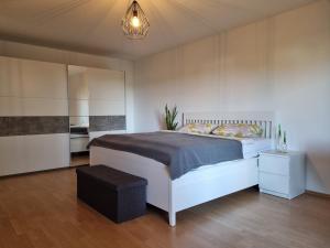 a bedroom with a large white bed in a room at Modernes Apartment mit Terasse in Lügde