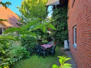 a table and chairs in a garden next to a brick building at Modernes Apartment mit Terasse in Lügde