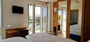 a hotel room with two beds and a balcony at Gästehaus Seeblick in Langenargen