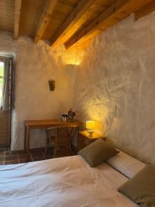 a bedroom with a bed and a table with a desk at Casa Aldea l'Ayalga in Beloncio +16 photos