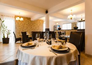 a table with a white table cloth and wine glasses at Hanul Conitei in Sovata