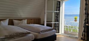 a bedroom with two beds and a sliding glass door at Gästehaus Seeblick in Langenargen