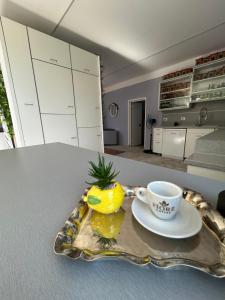 a plate with a cup and a pineapple on a table at La Terrazza in Tirana
