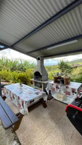 a picnic table under a roof with an outdoor oven at Gîte Délia Les Makes in Saint-Louis +4 photos