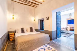 a bedroom with a bed and a living room at Marrakech Medina - Private Riad 4 rooms Rooftop and pools in Marrakesh
