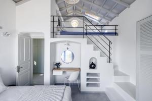 a bedroom with a staircase and a desk and a bed at Villa Aless in Skopelos Town