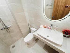 a bathroom with a toilet and a sink and a mirror at Harmony apartment in Noi Bai
