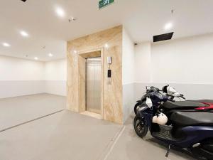 a motor scooter parked in a room with a door at Harmony apartment in Noi Bai