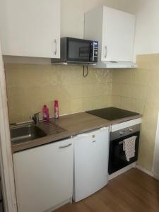 a small kitchen with a sink and a microwave at Le Cocoon - 2mn gare SNCF, hyper centre, WIFI-NETFLIX in Niort